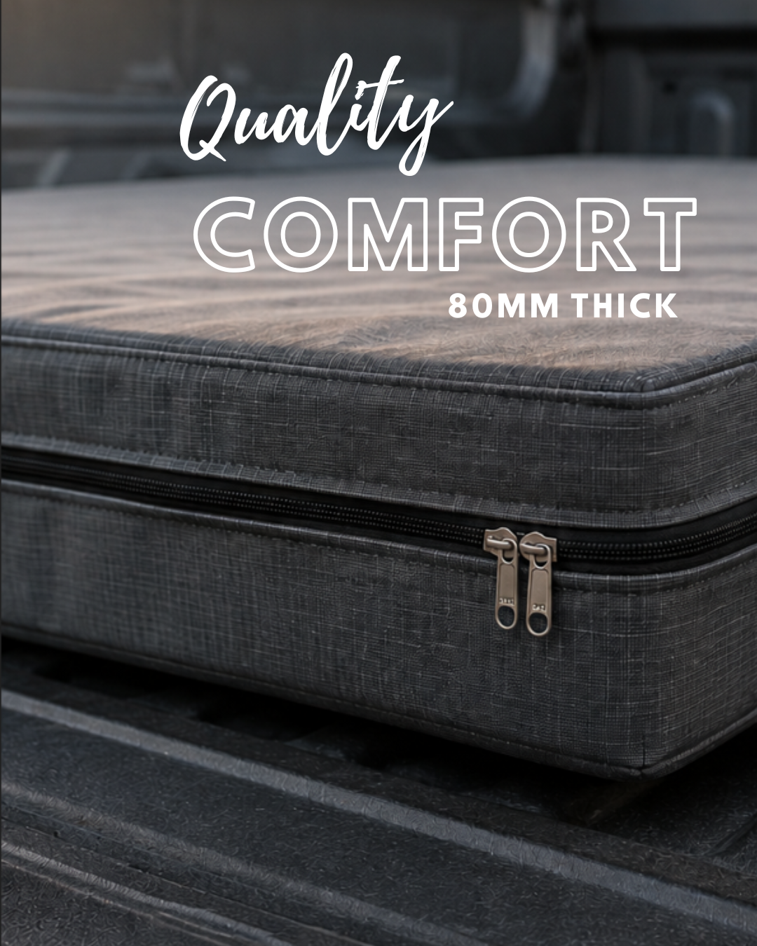 A dark gray textured comfort cushion with a black zipper and silver metal pulls, resting on a dark surface. White text overlay reads 'Quality COMFORT 80MM THICK'.
